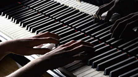 Hands playing a piano