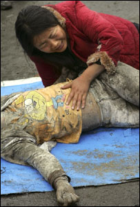 mãe chora ao lado do corpo da filha