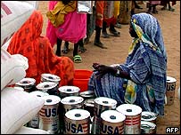 Refugiados sudaneses com alimentos de agências de ajuda humanitária