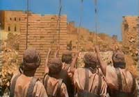 Joshua's army cheers as the walls of Jericho begin to crack and tumble