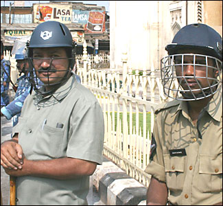 Policemen wearing cricket helmets