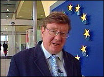 In front of an EU emblem