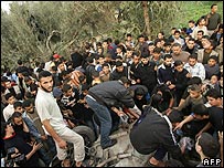 Palestinos ao redor de carro atingido no ataque