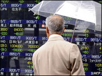 Homem observa desempenho de ações em Tóquio (AFP)