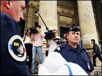 Um dos réus do caso cobre o rosto ao chegar ao tribunal