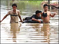 Chineses atravessam rua alagada
