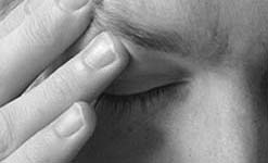 Blurred picture of a preson with their hand to their brow