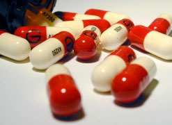A pharmacist measures pills into a bottle