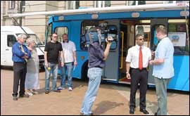 local TV crews interview the bus team