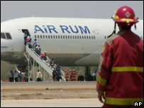 Bombeiro peruano observa desembarque de torcedores gambianos após pouso de emergência em Piura