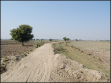 Pakistan's flood-affected landscape, showing a road surface reduced to sand