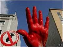 Manifestante ergue a mão suja de tinta vermelha em protesto contra a visita da secretária de Estado americana, Condoleezza Rice, à Grécia