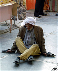 Homem parcialmente paralisado pede esmolas perto de uma loja de Bagdá, Iraque