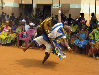 A dancer performs in front of a large crowd at the voodoo festival in Allada