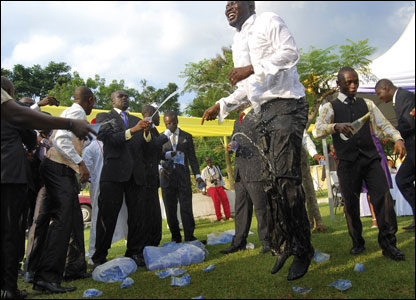 Guests delight in spraying the groom with bottles of bubbly at his wedding in Kumasi