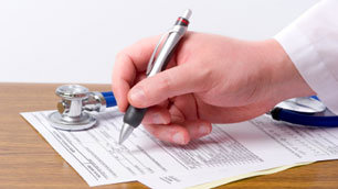 Close-up of a doctor filling out medical notes