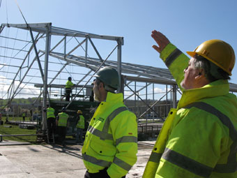 Gweithwyr yn edrych ar sgerbwd y pafiliwn yn cael ei godi