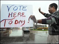 Voluntário de campanha exibe cartaz com dizeres de que já é possível votar