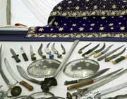 A display of swords and knives arranged in the shape of the Sikh Khalsa symbol