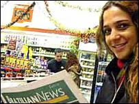 Brasileira lê jornal da comunidade