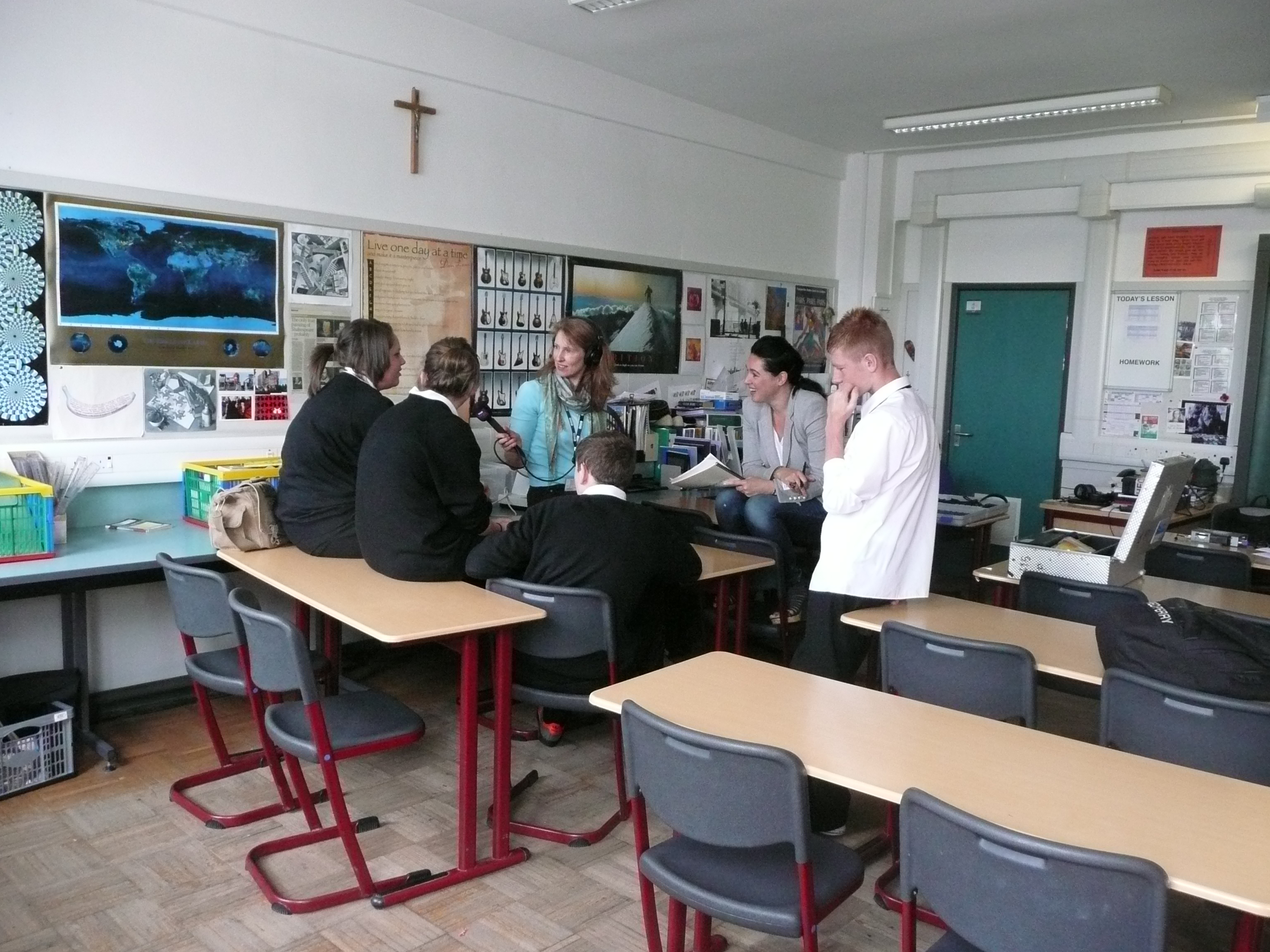 School pupils sitting on desks being interviewed