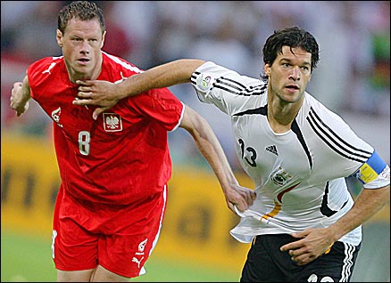 Jacek Krzynowek is held off by Michael Ballack