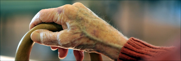 Anonymous shot of elderly person's hand on walking stick