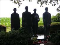 Men mourning their fallen comrade from Langemarck German Cemetery.