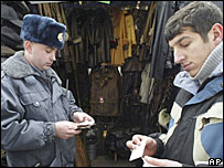 Bir yabancı işçinin belgelerini inceleyen polis