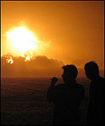 People look on as the smoke billows.