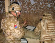 Chaplain Andrew Martlew and soldier, both in camouflage uniform, in an army base watchtower