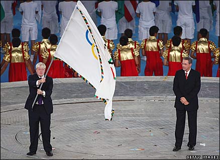 Boris Johnson waves the Olympic flag with Jacques Rogge