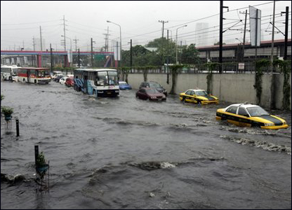 Xe cộ qua lại một khu vực bị ngập nước ở Manila