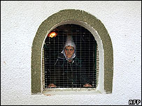 Mulher albanesa olha pela janela em Kosovo