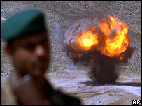 يک سرباز افغان در کنار يک مين منفجر شده