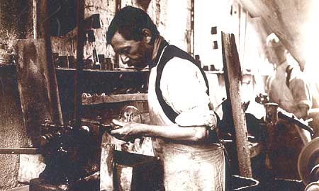 Worker grinding a decanter neck in the stoppering shop