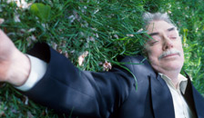 a man sleeping on a grassy lawn