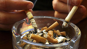 Smokers stubbing out cigarettes in an ashtray