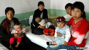 甘肅蘭州某軍醫院內家長抱著患有腎結石的嬰兒（新華社圖片11/9/2008）