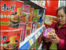 一位女士查看康师傅方便面的价格 (新华社图片)