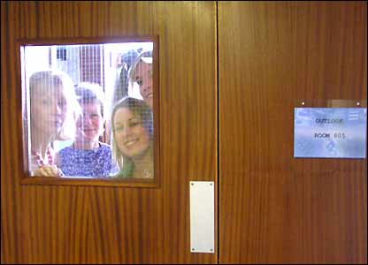 Outlook team members looking through the door of the Outlook office