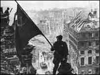 Sovětský voják vztyčuje vlajku na Berlínem v květnu 1945