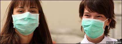 Two women wearing surgical masks