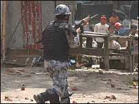 Policial persegue manifestantes no Nepal