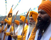 Sikh men in turbans with swords in a festival procession