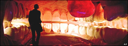 Someone walking through a large model of a mouth