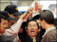 Ông Trần Thủy Biển giơ tay bị còng bên ngoài công tố viện