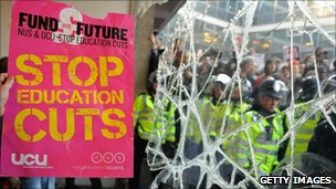 'Stop education cuts' placard in front of broken glass, police and protesters
