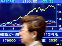 Mulher passa em frente a painel na bolsa de Tóquio