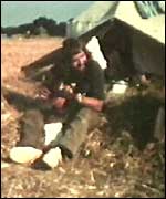 Man playing the guitar outside a tent